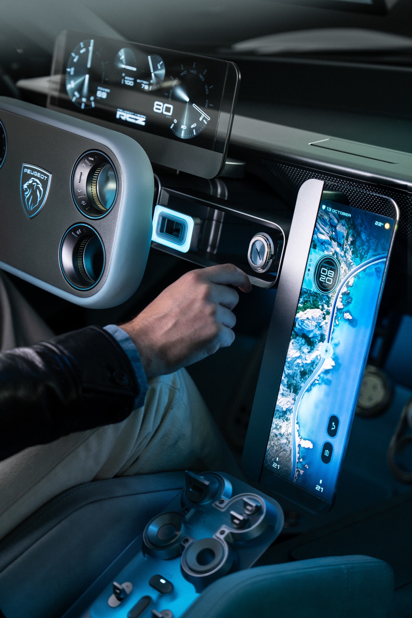 A hand reaches for the watch set into the dashboard of the concept car